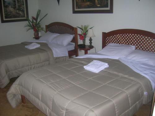 dos camas sentadas una al lado de la otra en un dormitorio en Hotel Esperanza, en Carrillo