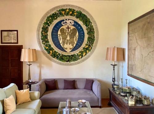 a living room with a couch and a plate on the wall at Castello in Lucignano