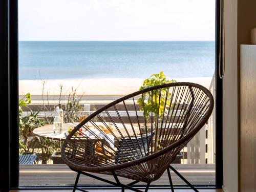 a chair sitting on a balcony with a view of the beach at そらすな Beach Side Resort Hotel in Yukuhashi