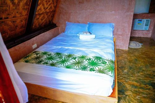 a bed with blue pillows and a bag on it at Ciudad Caliente by The Lavana in Talisay