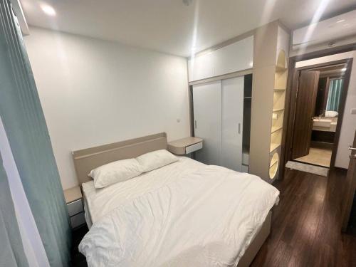 a small bedroom with a white bed and a mirror at TC Apartment & Homestay 3 in An Khê