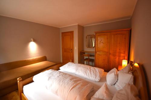 a bedroom with two beds with white sheets at Brunnenhof Apartments in Pettneu am Arlberg