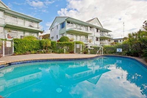 a swimming pool in front of a house at 2 Ocean Shores in Peregian Beach