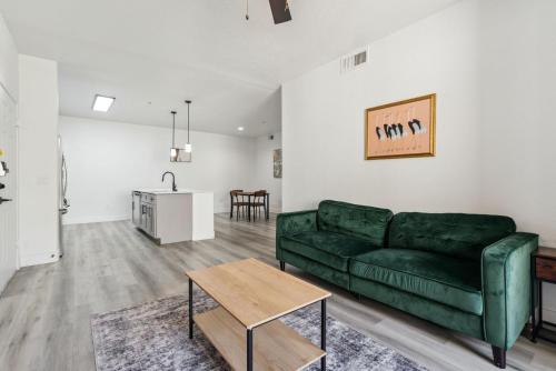 a living room with a green couch and a table at CozySuites Glendale - Westgate with pool 06 in Glendale