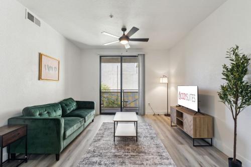 a living room with a green couch and a table at CozySuites Glendale - Westgate with pool 06 in Glendale