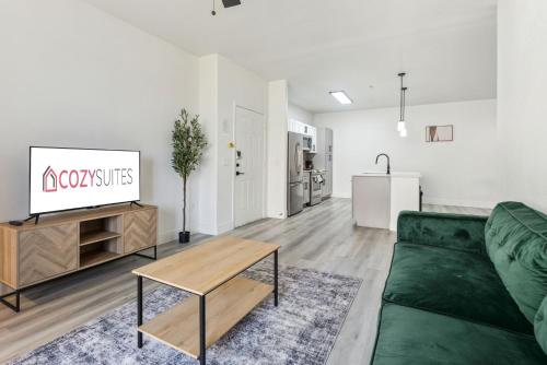 a living room with a green couch and a table at CozySuites Glendale - Westgate with pool 06 in Glendale