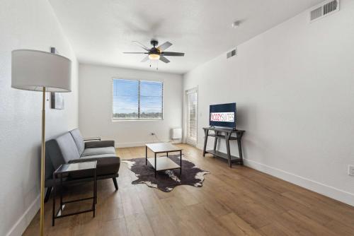 a living room with a couch and a ceiling fan at CozySuites Glendale - Westgate with pool 05 in Glendale