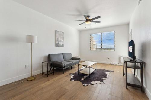 a living room with a couch and a ceiling fan at CozySuites Glendale - Westgate with pool 05 in Glendale