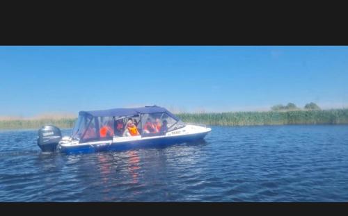 a group of people in a small boat on the water at Pensiunea Maria Agighiol in Agighiol