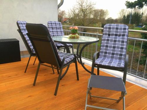 three chairs and a table on a balcony at Alte Heimat in Schwegenheim