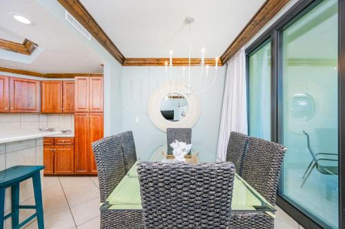a dining room with a glass table and chairs at Phoenix on the Bay 1527 condo in Orange Beach
