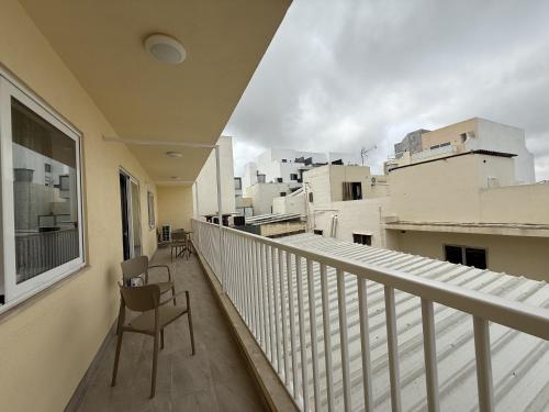 a balcony with two chairs and a view of buildings at New Apartment! Walking distance to the three cities by SF Homes in Fgura