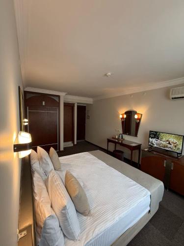 a bedroom with a large white bed with pillows at OTEL KÂYA in Izmir