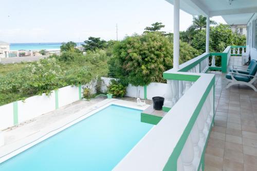 a swimming pool on the balcony of a house at Villa Donna Inn in Montego Bay