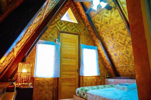 a room with a bed and two windows in a house at Ciudad Caliente by The Lavana in Talisay