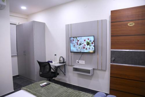 una stanza con una scrivania e una TV a parete di Yendluri's- QueenBed Room-24 Kondapur, Gachibowli a Lingampalli