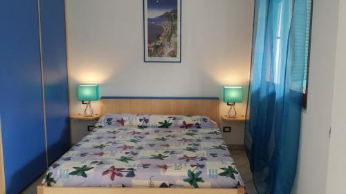 um quarto com uma cama e duas lâmpadas em duas mesas em Case Sole e Luna em Porto Azzurro