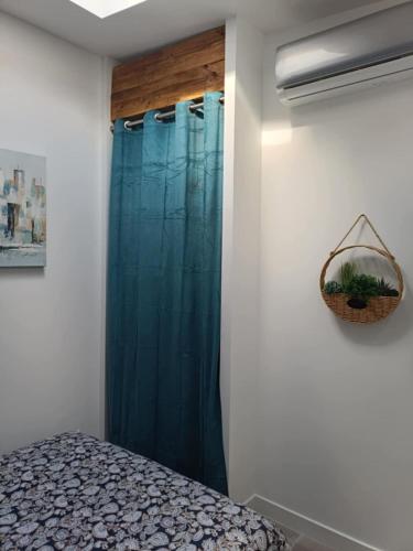 - une chambre avec un rideau de douche bleu et un lit dans l'établissement Appartement au Somail, à Saint-Nazaire-dʼAude