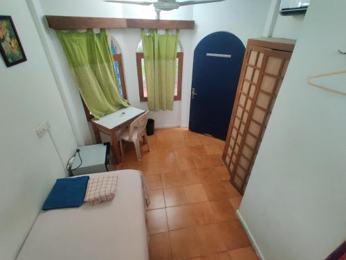 a room with a couch and a table and a door at New Creation Guest House in Auroville