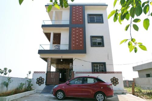 a red car parked in front of a house at Suhana Aangan Homestay in Tirupati