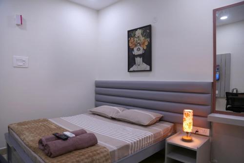 Dormitorio con cama con espejo y lámpara en Yendluri's- QueenBed Room-26 Kondapur, Gachibowli, en Lingampalli