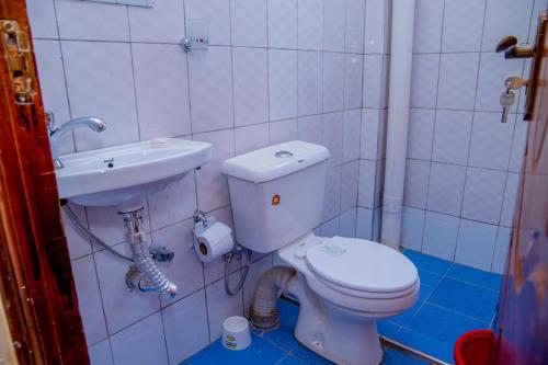 a bathroom with a toilet and a sink at IT IS WELL Homes in Kisii
