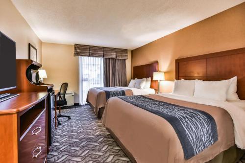a hotel room with two beds and a desk at Comfort Inn & Suites Ambassador Bridge in Windsor
