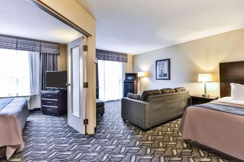 a hotel room with a bed and a couch and a television at Comfort Inn & Suites Ambassador Bridge in Windsor