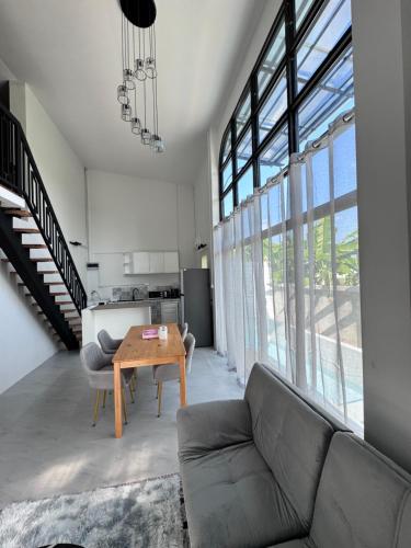 a living room with a couch and a table at Chiangmai Courtyard Residence บ้านสวนสวย บ้านถวาย in Bān Sawan
