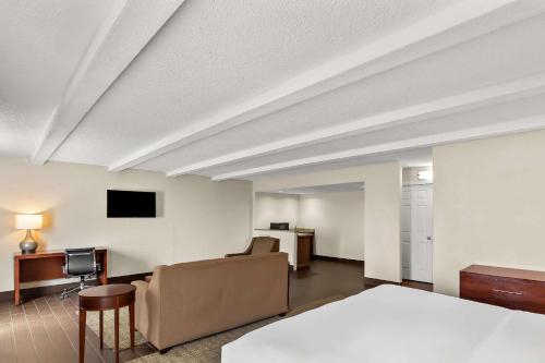a hotel room with a bed and a desk at Comfort Inn St Louis - Westport Event Center in Maryland Heights