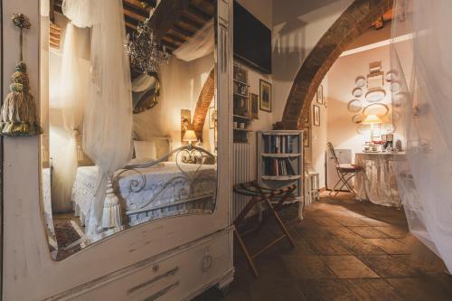 a bedroom with a bed and a mirror at La Romantica Lolo' in Montepulciano