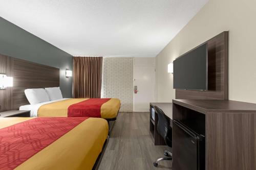 a hotel room with two beds and a flat screen tv at Econo Lodge in Creedmoor