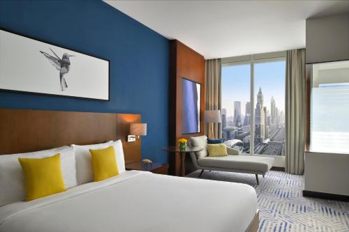 a hotel room with a bed and a large window at voco Dubai by IHG in Dubai