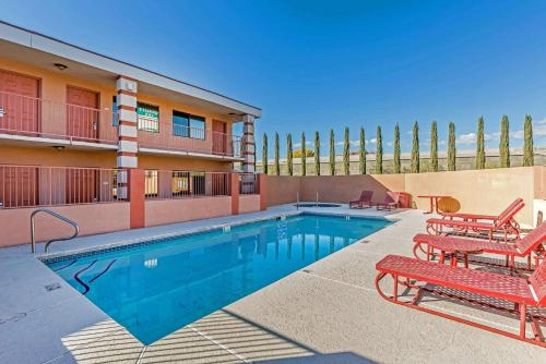 a swimming pool with two chairs and a bench next to a building at Quality Inn Washington - St George North in Washington