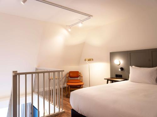 a hotel room with a bed and a chair at DoubleTree by Hilton Sittard in Sittard