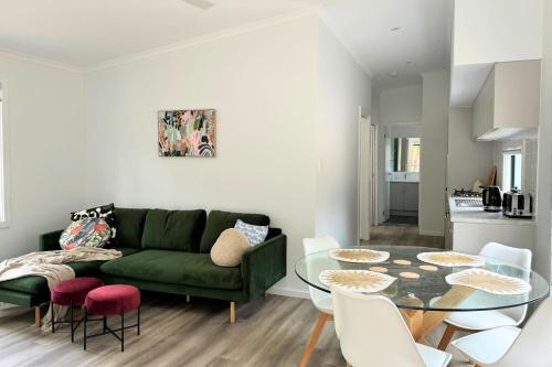 a living room with a green couch and a glass table at The Cabins at Douglas Scrub in Blewitts Springs