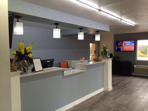 an office with a reception counter with flowers on it at Lotus Inn and Suites Nashville in Nashville