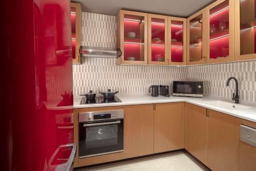 a kitchen with wooden cabinets and a stove top oven at Andaz Doha, by Hyatt in Doha