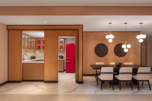 a kitchen with a table and a red refrigerator at Andaz Doha, by Hyatt in Doha