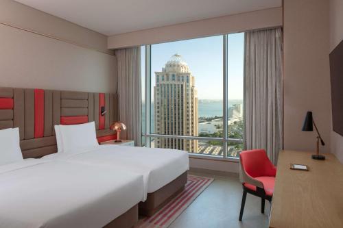 a hotel room with a large bed and a large window at Andaz Doha, by Hyatt in Doha