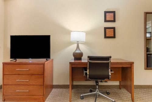 an office with a desk with a chair and a television at Comfort Inn & Suites Black River Falls I-94 in Black River Falls