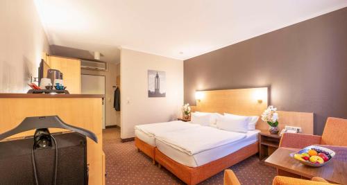 a hotel room with a bed and a table at Sure Hotel by Best Western Hilden-Düsseldorf in Hilden