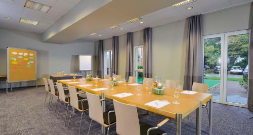 a conference room with a long table and chairs at Sure Hotel by Best Western Hilden-Düsseldorf in Hilden