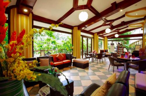 a living room with couches and chairs and tables at Boracay Paradise Garden Hotel By Tripzy Fun in Boracay