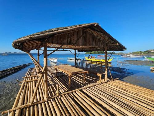 a wooden hut with a bench on the beach at Leopoldo's Kampsite and Sports Cafe in Cruz