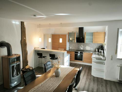 a kitchen and dining room with a table and a stove at Tor zum Saueland mit Sauna und Whirlpool in Olpe