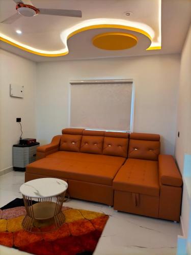 a living room with a brown couch and a table at Suhana Aangan Homestay in Tirupati