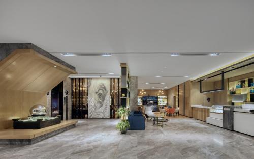 a lobby of a building with a lobby at Echarm International Hotel Pazhou Convention and Exhibition Center Nanzhou Metro Station Branch - Free Shuttle Bus to Canton Fair Complex During Canton Fair Period in Guangzhou