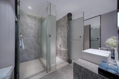 a bathroom with a shower and a sink and a tub at Echarm International Hotel Pazhou Convention and Exhibition Center Nanzhou Metro Station Branch - Free Shuttle Bus to Canton Fair Complex During Canton Fair Period in Guangzhou