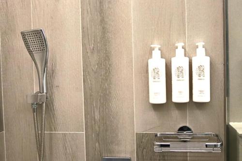 a bathroom with two shampoo bottles on a wall at Casa Royale Vacation Home - JVC in Dubai